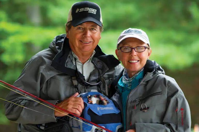 Barry and Cathy Beck in fly fishing garb smiling for the camera.