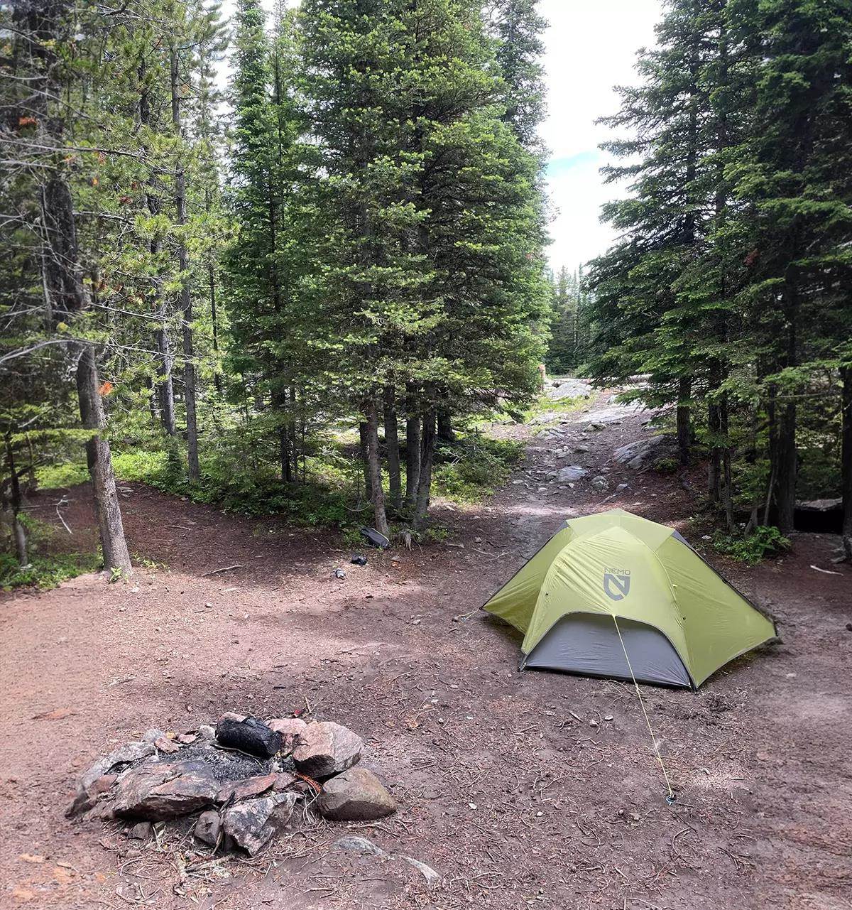 A NEMO tent in a mountain and treed landscape.