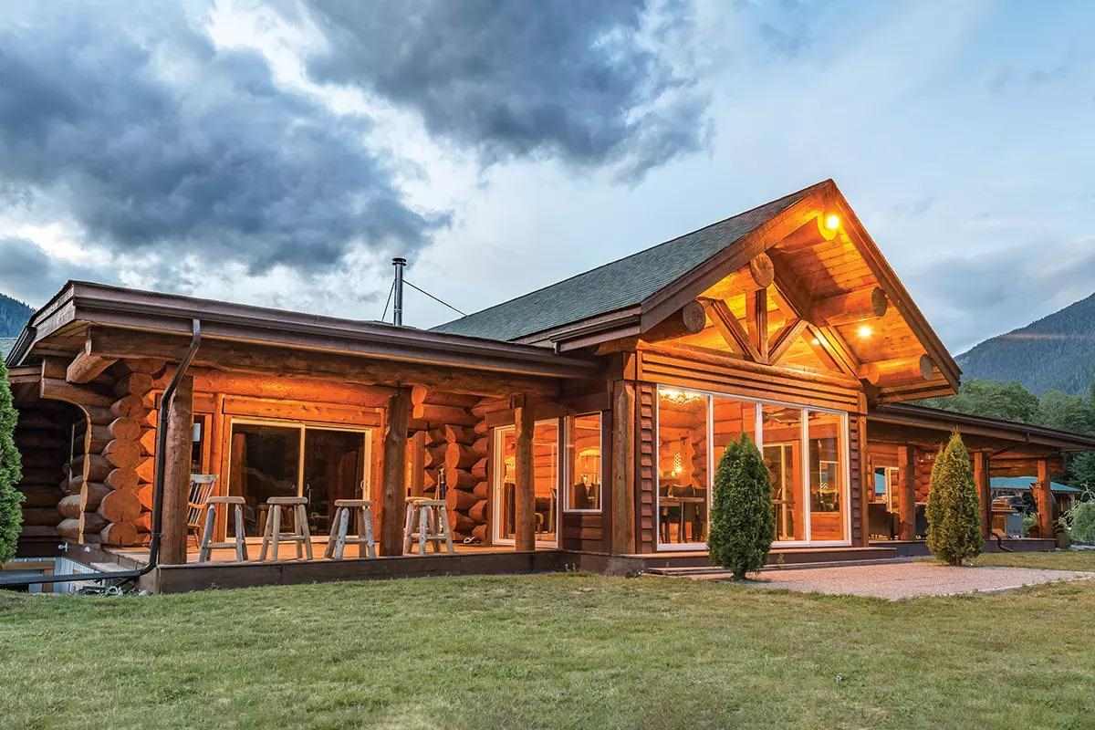 A fancy log-cabin fishing lodge under dark skies. 