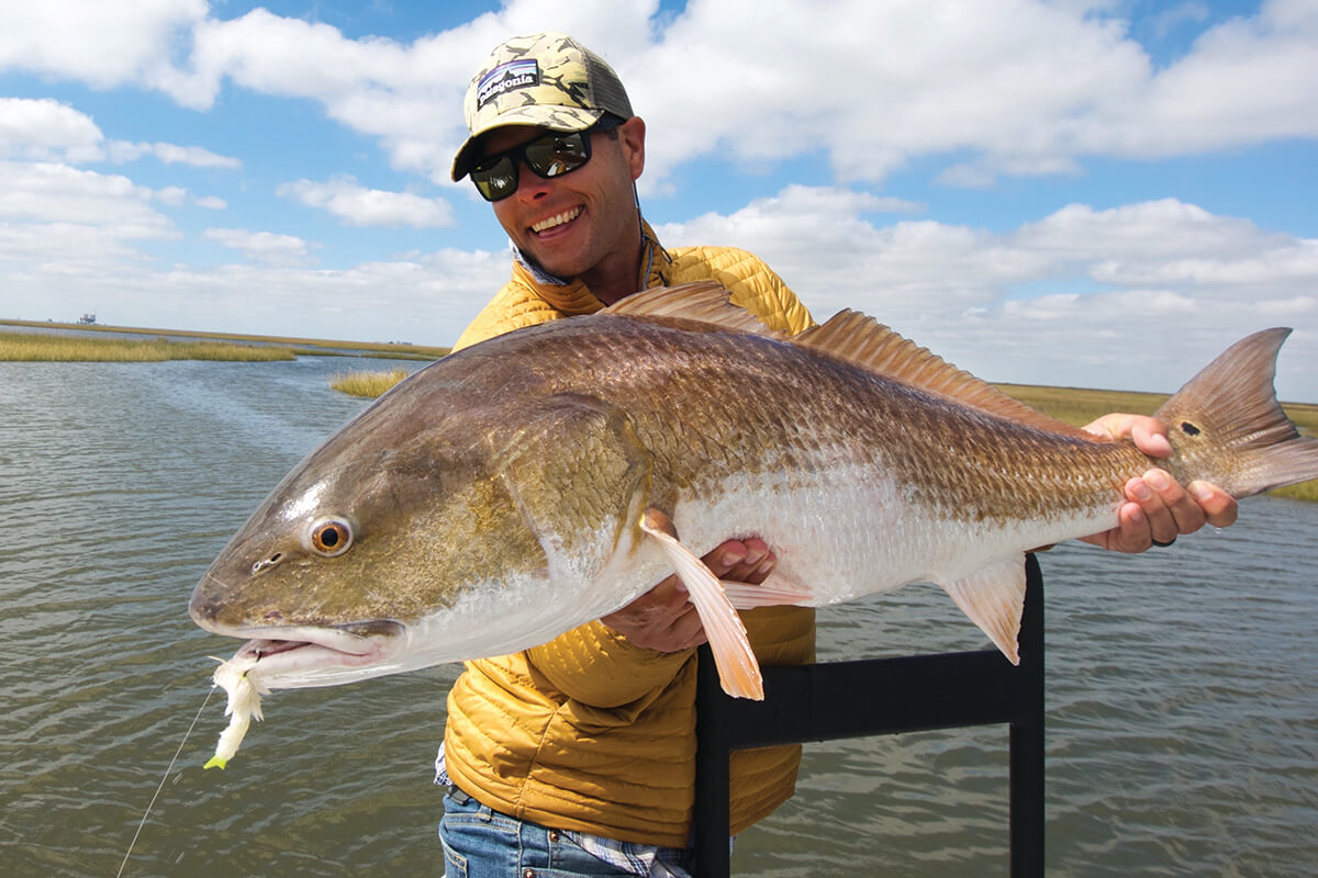 Author and fly fishing guide Blane Chocklett holding a large redfish