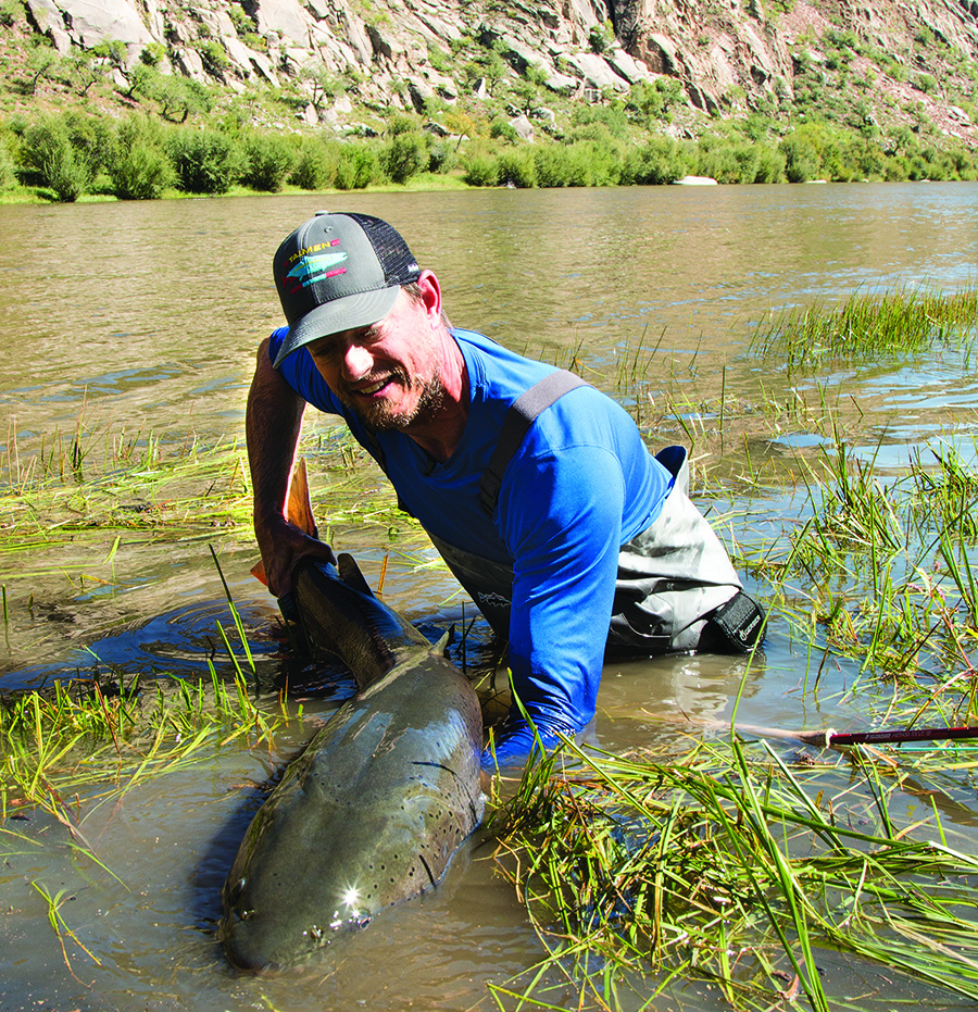 A fly angler holding a large taimen
